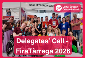 A group of over twenty people are gathered in front of a booth and smile at the camera. Text reads - Delegates' Call FiraTàrrega 2026